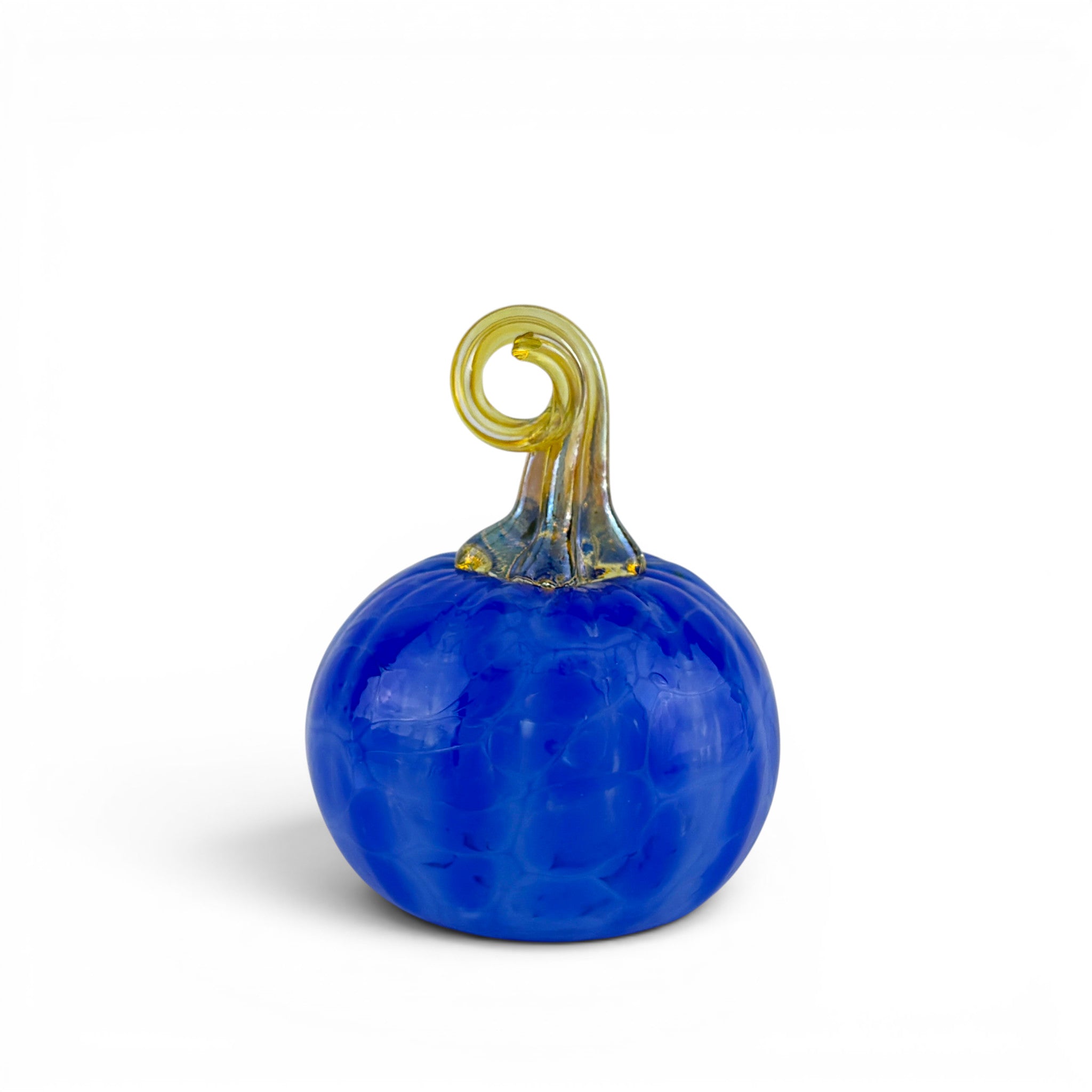 A small decorative glass pumpkin with a vibrant cobalt blue body and a translucent yellow-green stem, photographed on a clean white background.