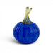 A decorative glass pumpkin figurine with a deep cobalt blue body and a translucent yellow-green stem, shown on a clean white background.
