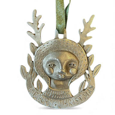 Decorative Christmas ornament with face design and 'Merry Christmas' text on a white background