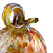 Close-up of a hand-blown glass decorative object with a curved amber loop handle and a rounded transparent body containing orange, yellow, and brown marbled swirls, photographed on a white background.