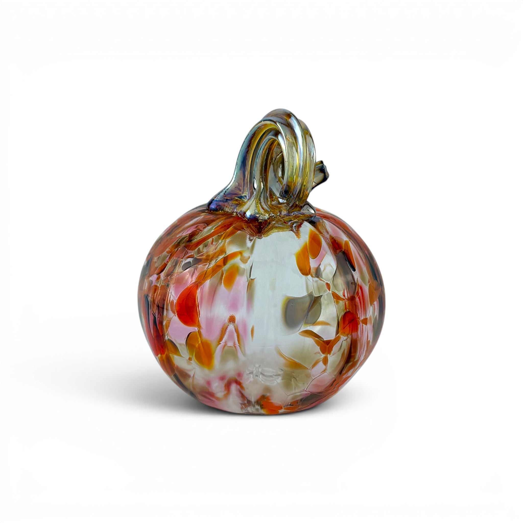 A hand-blown glass pumpkin ornament with a swirling marbled pattern of orange, red, white, and brown, featuring a small loop handle on top, set against a plain white background.