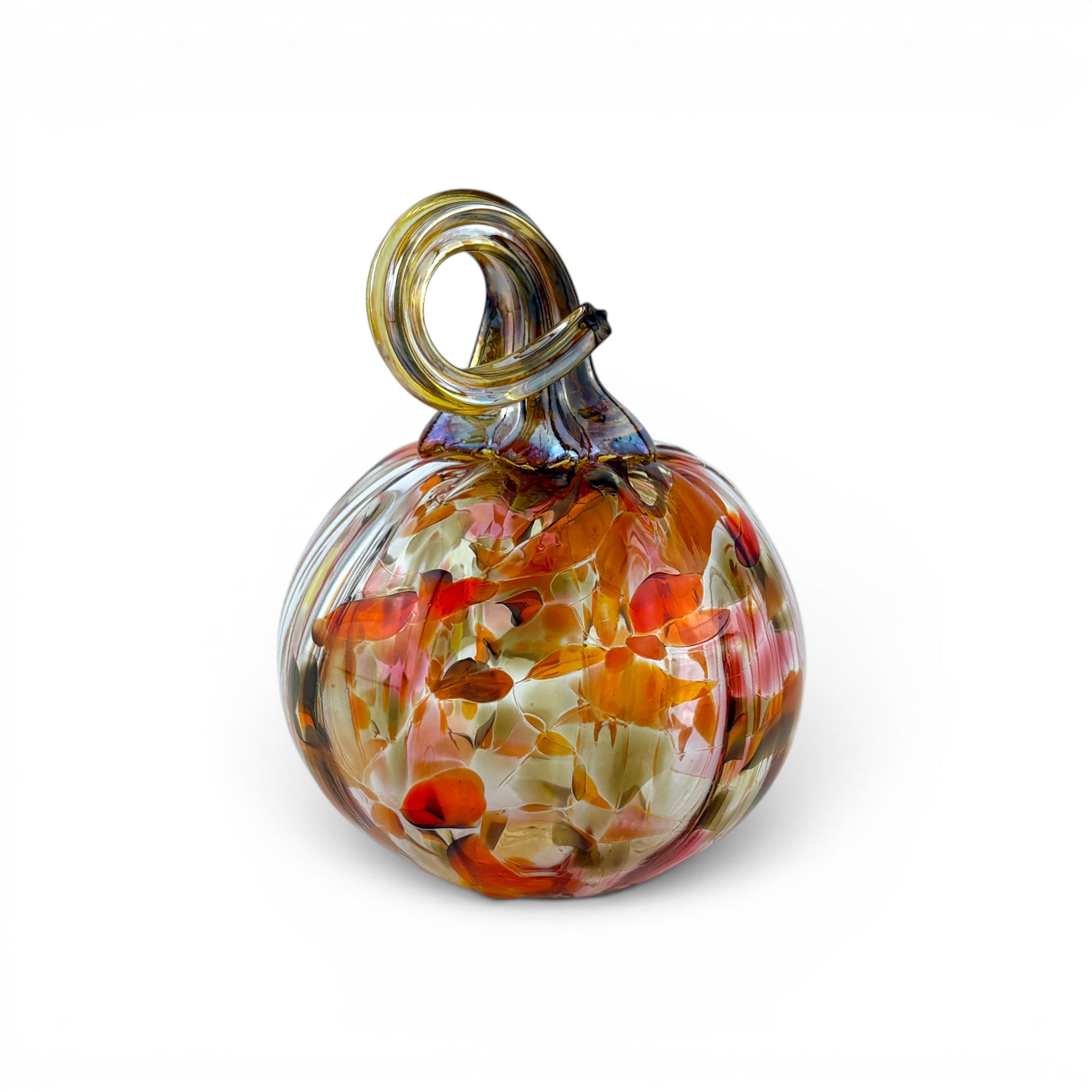 A hand-blown glass decorative pumpkin with a loop handle, featuring a marbled pattern of orange, red, yellow, and clear glass on a white background.