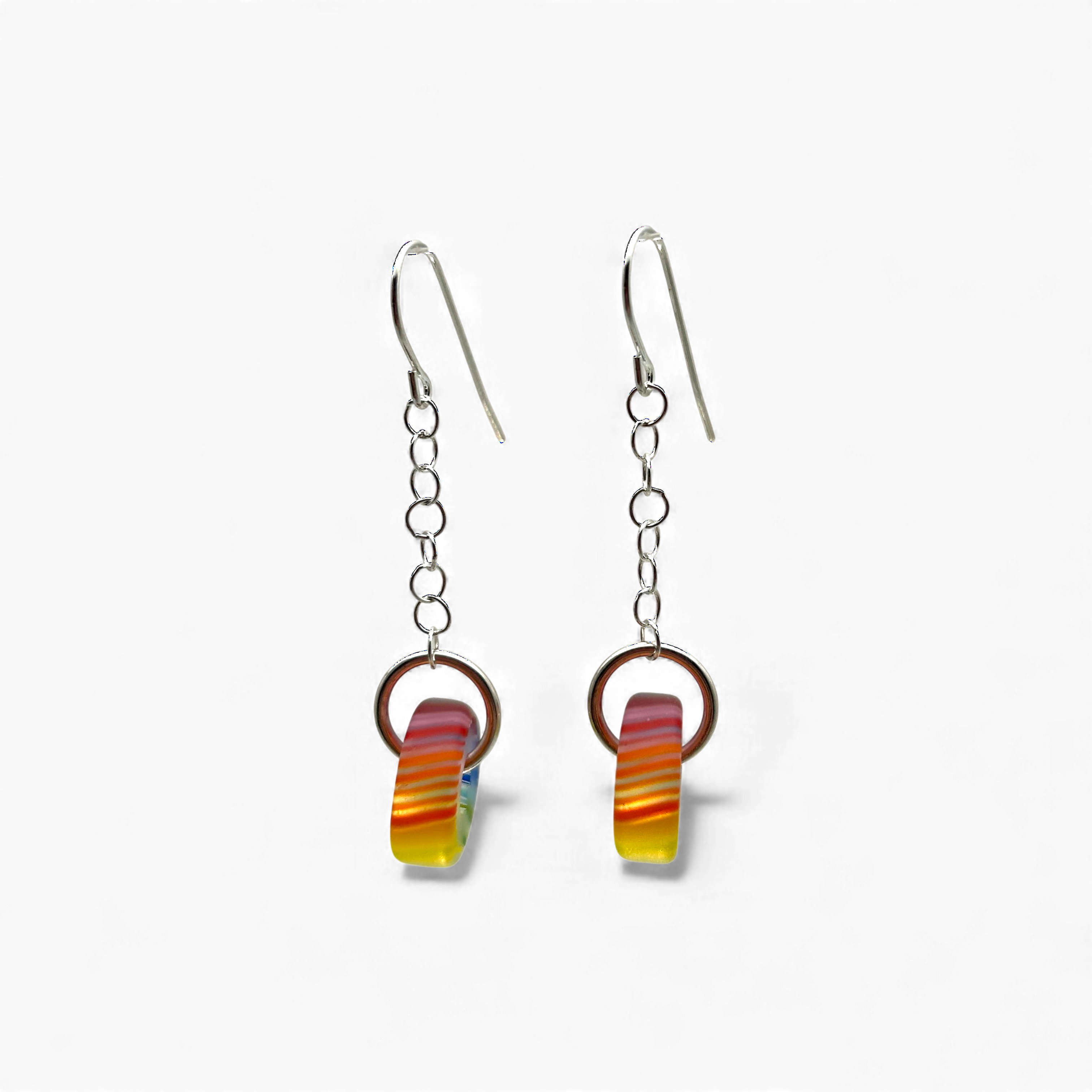 Pair of earrings with colorful circular designs on a white background