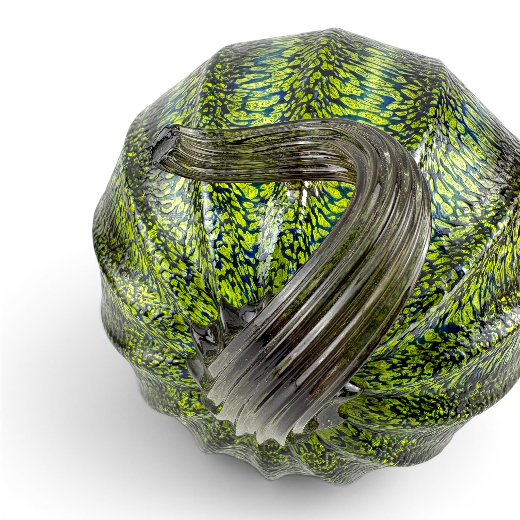 A handcrafted glass pumpkin with a ribbed side, featuring a vibrant lime green and black marbled pattern with a thick, ribbed clear glass handle.   