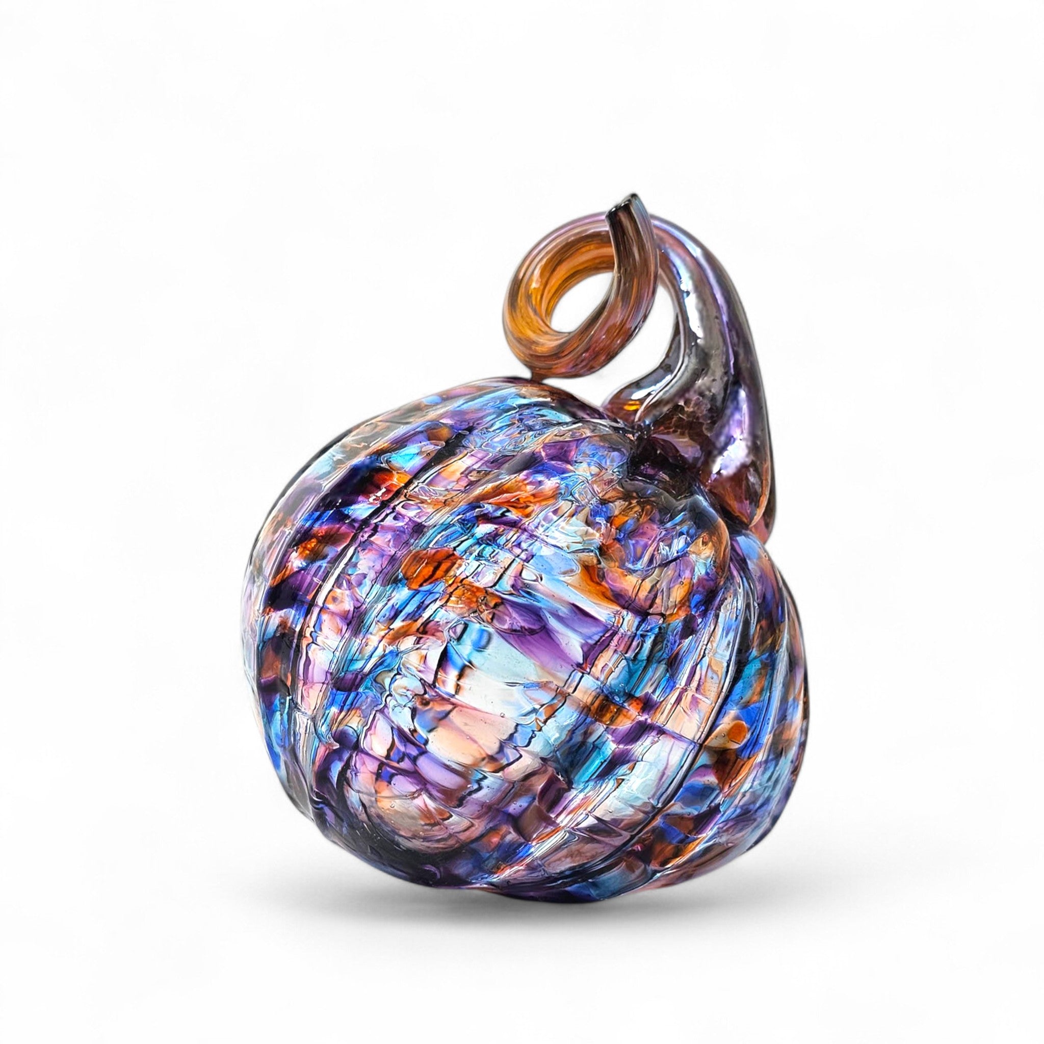 Multicolored glass pumpkin with a golden brown stem on a white background