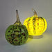Two orchard glass pumpkins, one green and one yellow with brown speckles, on a gray background.