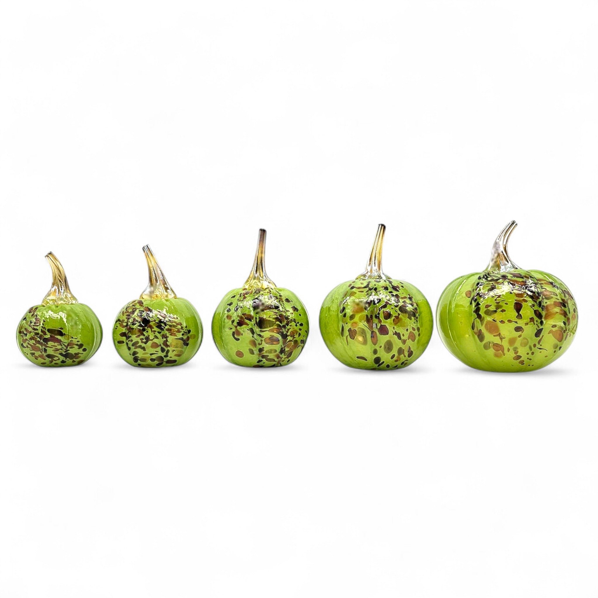 Set of six green decorative pumpkins with speckled patterns on a white background