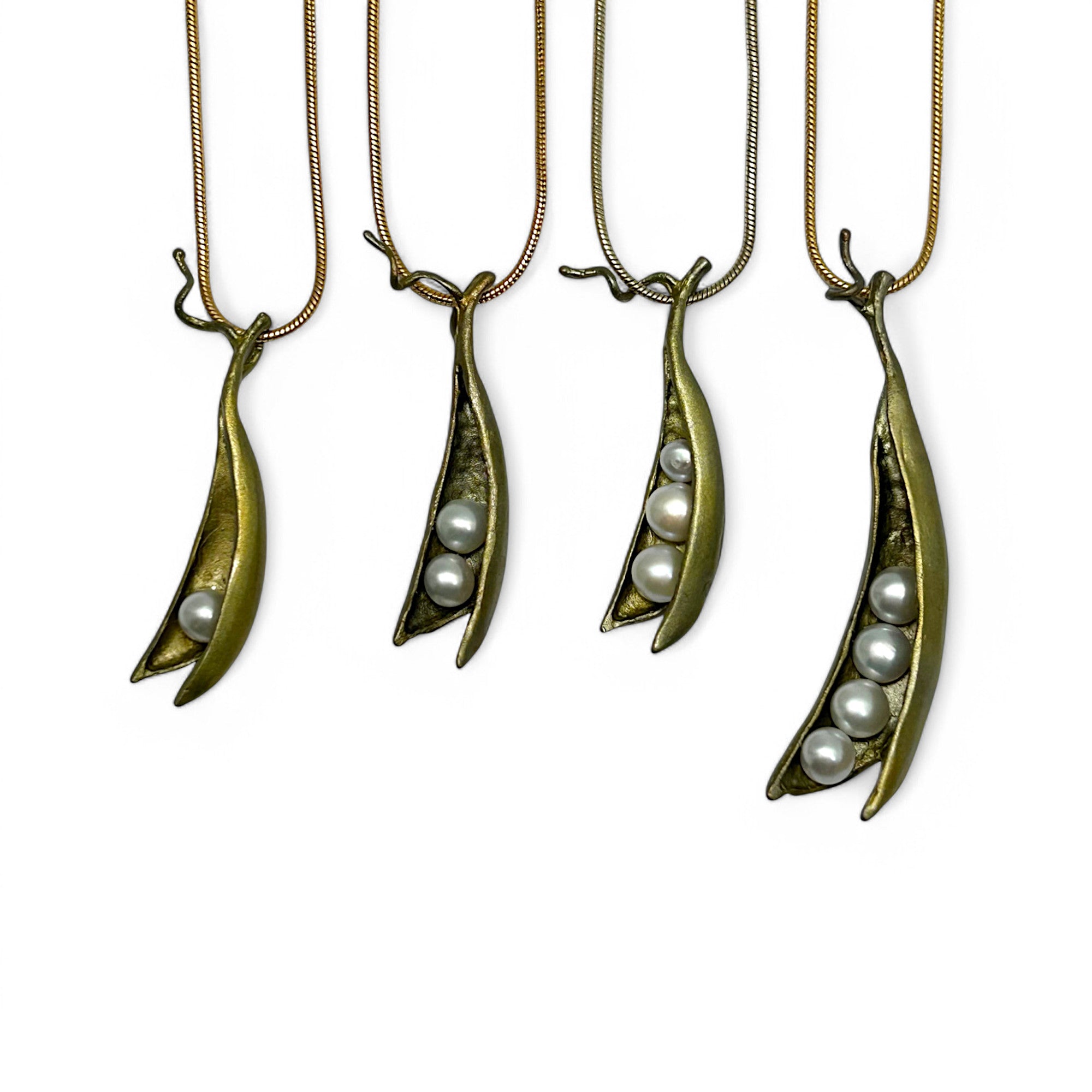 four different cast bronze pea pod necklaces, each with one, two, three, or four freshwater pearls nestled inside the pod