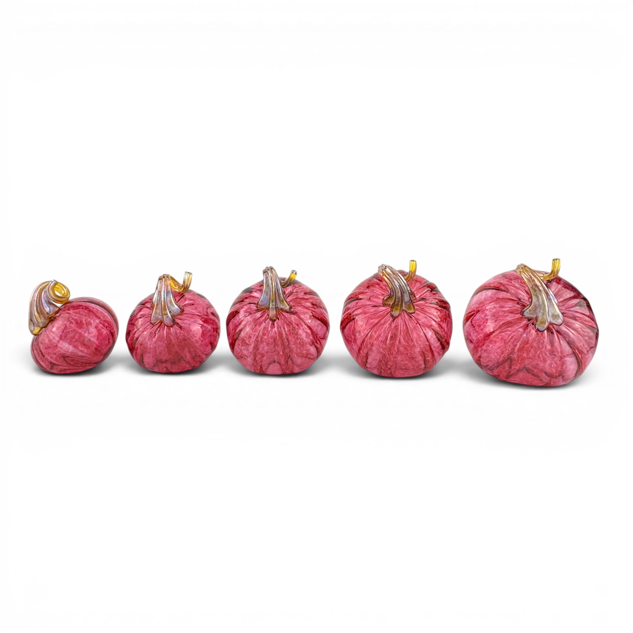 Five decorative glass pumpkins arranged in a row, graduating in size, featuring a textured pink and red marbled pattern with gold-toned stems, set against a plain white background.