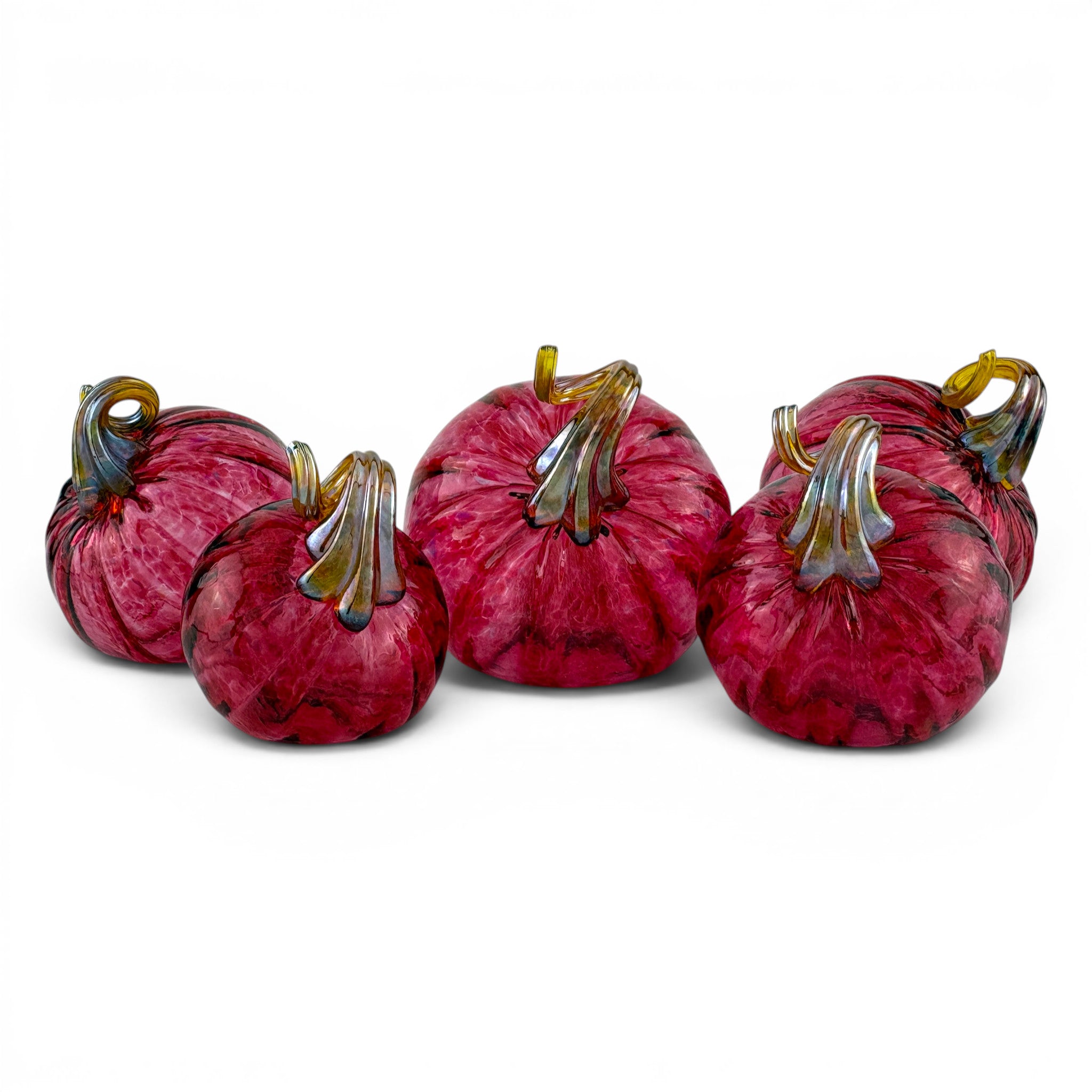 Five decorative glass pumpkins in shades of deep magenta and burgundy, featuring textured marbled patterns and metallic gold and green stems, arranged on a white background.