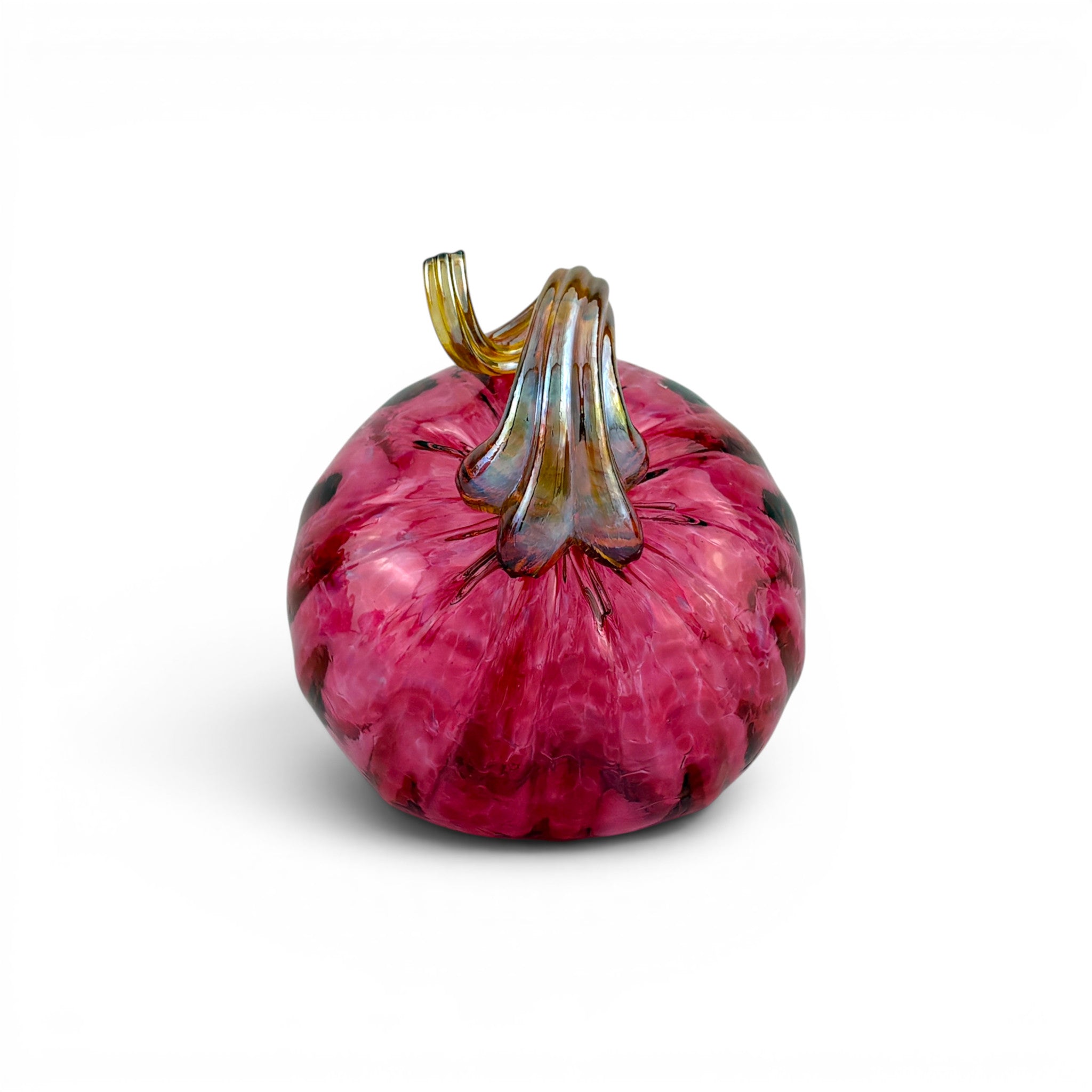 A hand-blown glass decorative pumpkin in vibrant magenta pink with dark marbled accents and a textured amber-brown stem, set against a plain white background.