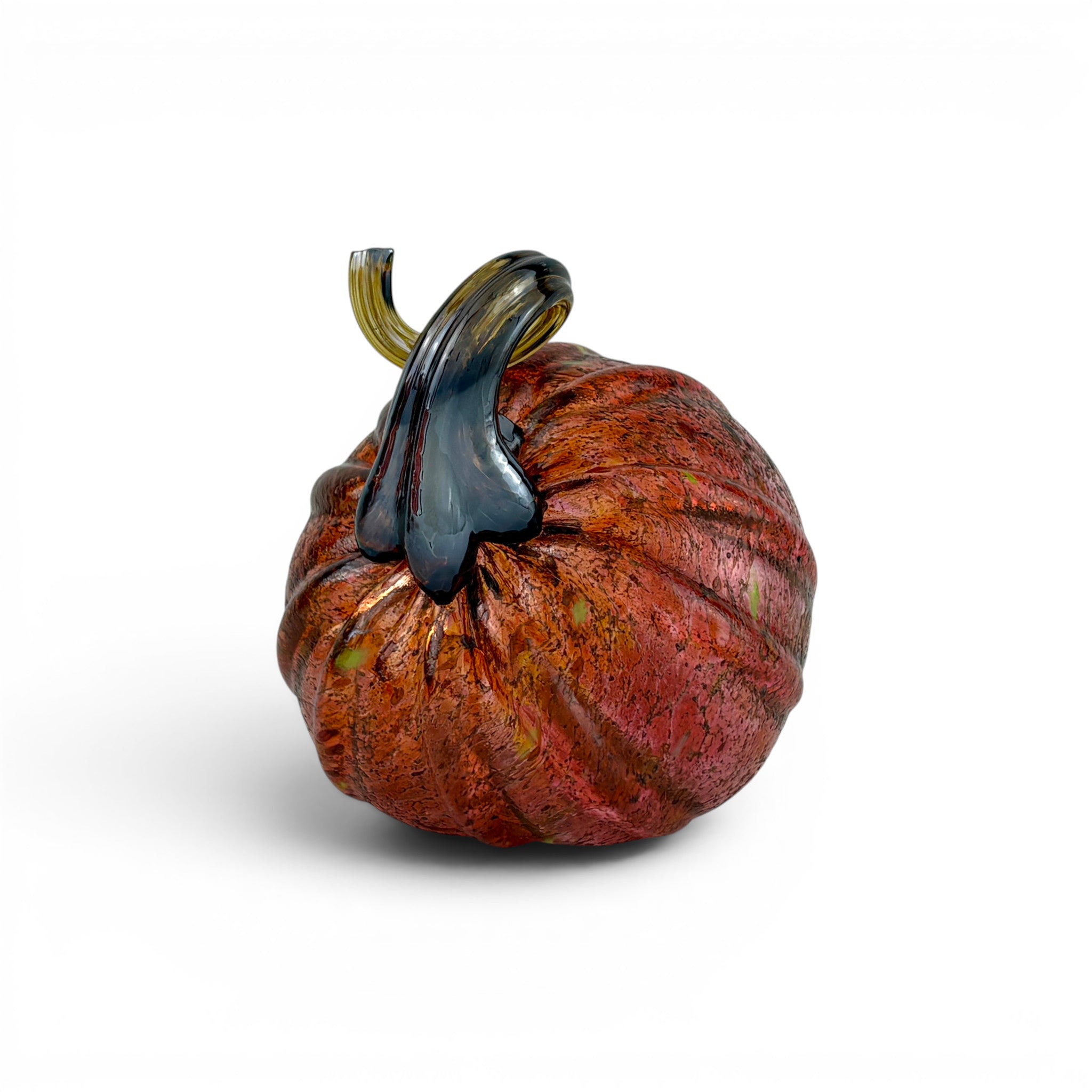 A handcrafted glass pumpkin sculpture with a ribbed, rounded body in warm reddish-brown and orange tones, featuring a glossy dark blue-gray stem and a small gold accent near the top, set against a plain white background.