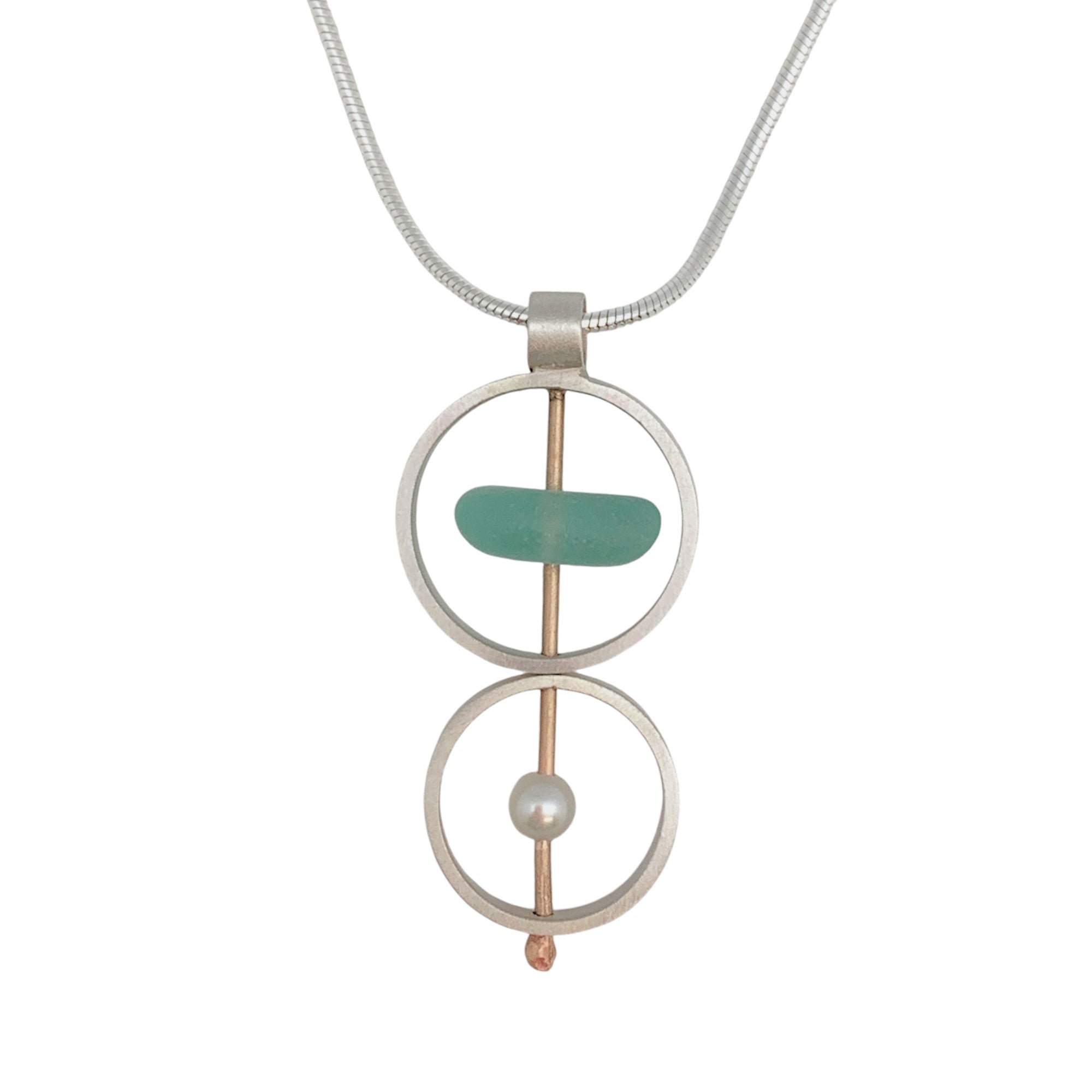 A brushed sterling silver and gold fill necklace with a pendant featuring naturally tumbled seaglass and an accent pearl, suspended from an 18-inch serpentine silver chain.