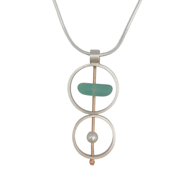 A brushed sterling silver and gold fill necklace with a pendant featuring naturally tumbled seaglass and an accent pearl, suspended from an 18-inch serpentine silver chain.