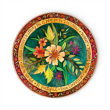 Decorative plate with floral design and inspirational text on a white background