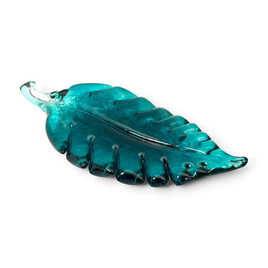 A handcrafted translucent teal-blue glass leaf sculpture. 