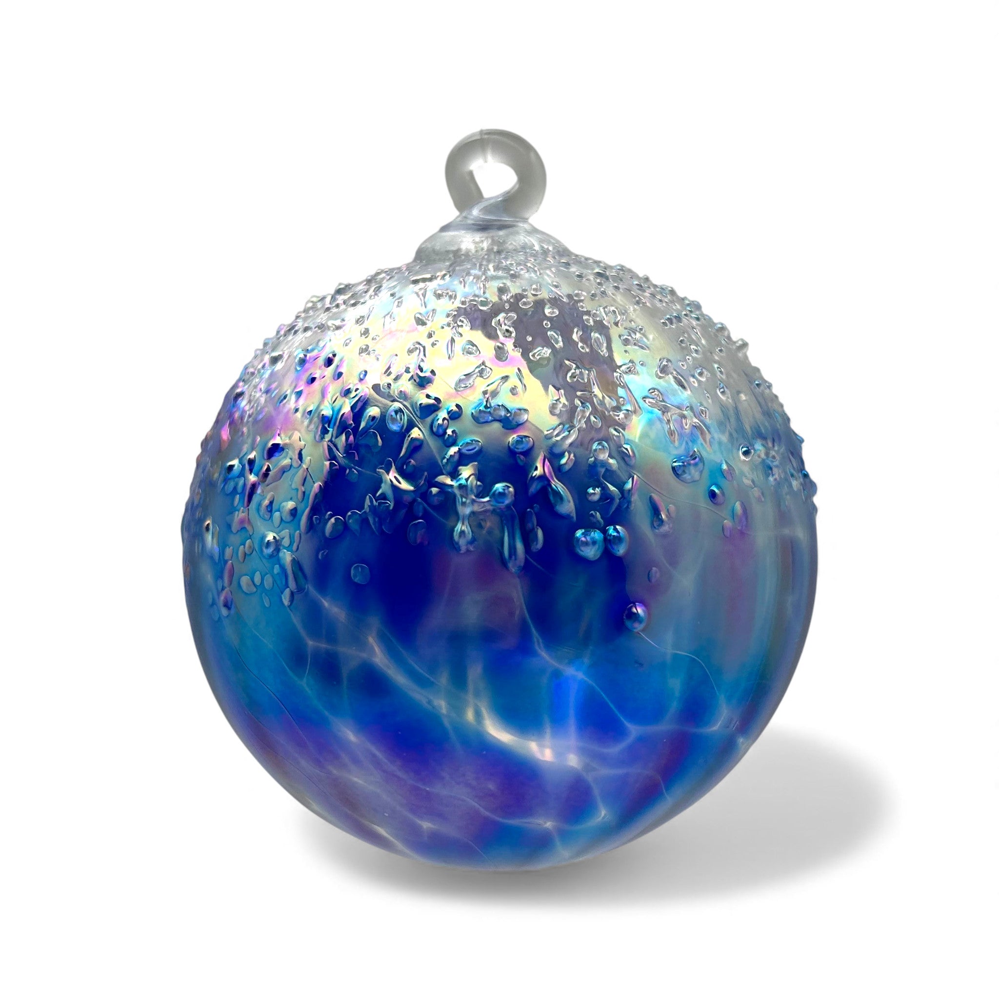 Glass ornament with blue and purple hues on a white background