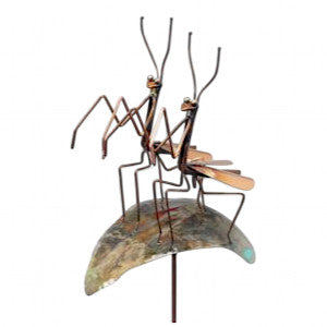 two praying mantis sculptures on a copper leaf