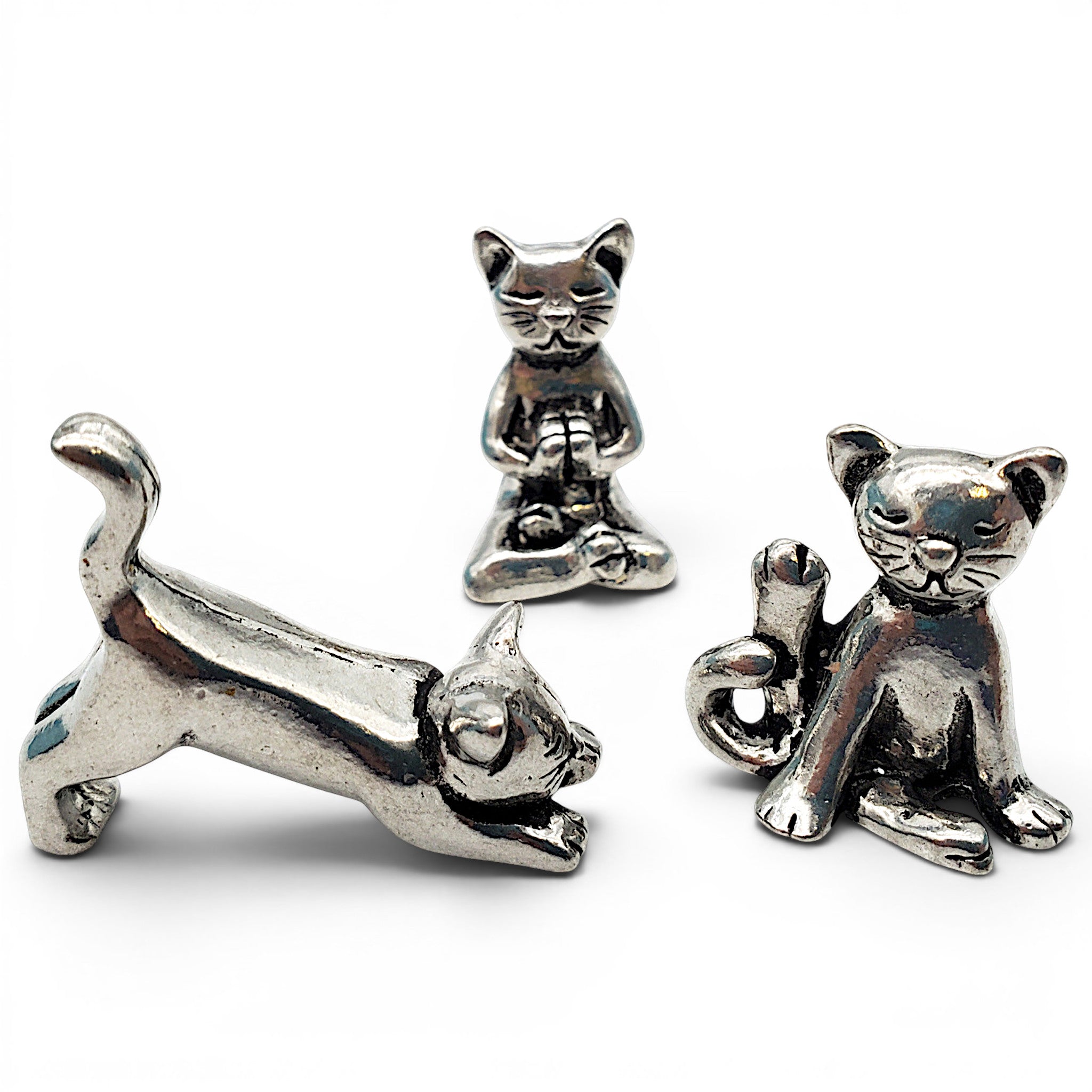 Three silver cat charms on a white background