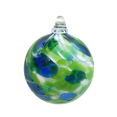 A handcrafted glass ornament with shades of green, blue, and white, featuring a solid pattern.