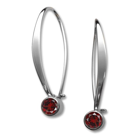 A pair of handcrafted, slender silver earrings with garnet gemstone accents.