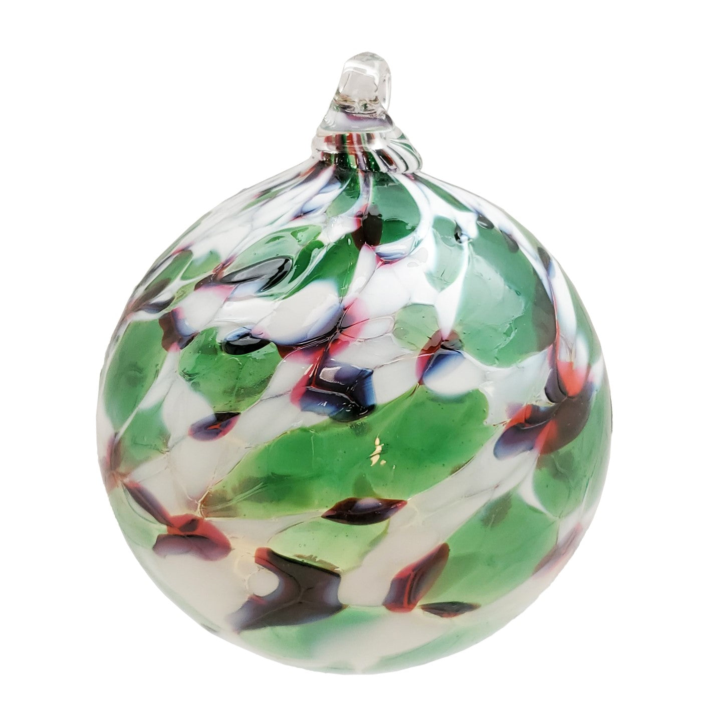 A round glass hand-blown festive ornament with swirls of red, green, and white, with a visible artist signature.