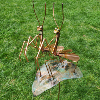 copper garden stake with a male and female praying mantis