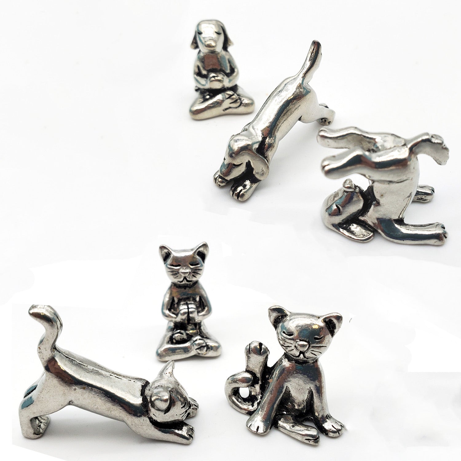 A collection of handcrafted pewter sculptures in the form of cats and dogs in various yoga poses.
